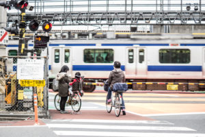 Locals in front of a railroad crossing in Tokyo Locals in front of a railroad crossing in Tokyo